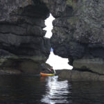 A kayaker paddling through the arches